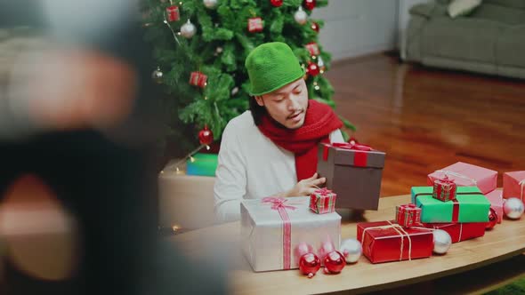 Attractive Asian men checking the gift box in the living room.