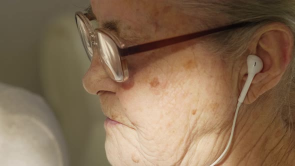 Senior Woman with Headphones Video Calling at Home 