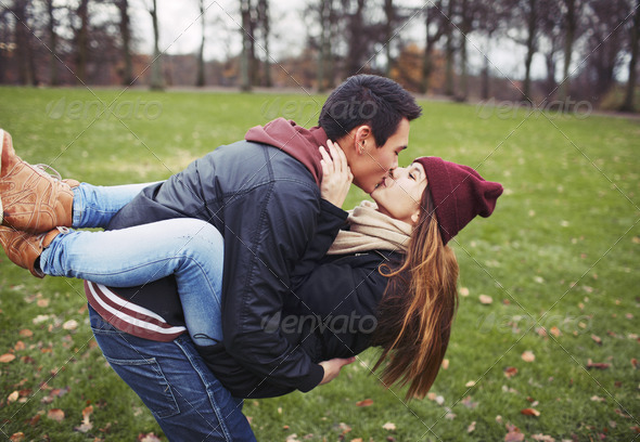 Sweet young couple sharing a kiss while out on a date - Stock Photo - Images