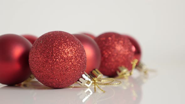 Red color assorted Christmas baubles close-up 4K tilting footage alt
