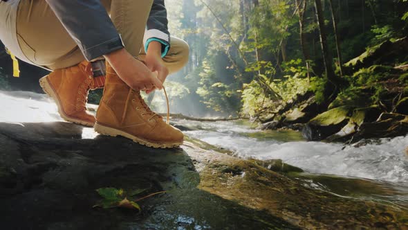 The Tourist Ties Up His Shoelaces on His Shoes alt