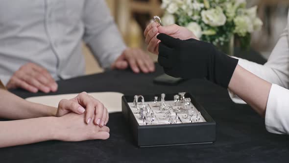 Saleswoman Presenting Silver Ring in Luxury Jewelry Shop alt