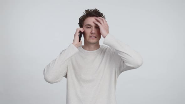 Attractive Young Man Looking Troubled After Receiving a Phone Call