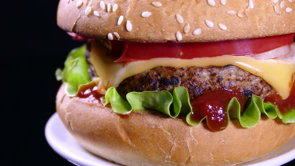 Appetizing burger on a black background. Delicious fast food.