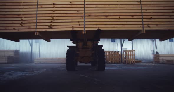 The loader is carrying the floorboards. Warehouse of a woodworking plant. Board floor loading