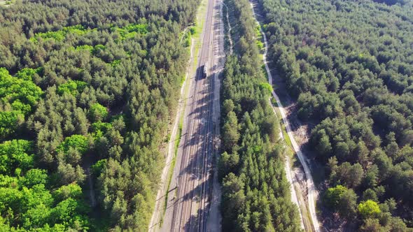 Aerial View of Railroad with Train in Sunny Summer Day in Forest