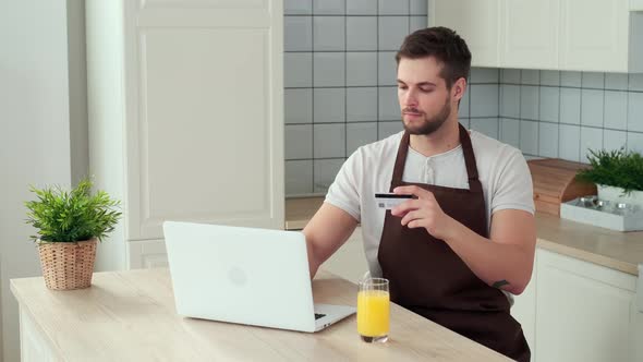 A Man Pays for Online Food Delivery to His Home Using a Credit Card alt