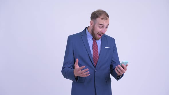 Happy Bearded Businessman Using Phone and Getting Good News