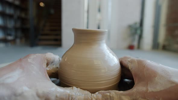Cinemagraph Loop of Beautiful Vase Made of Clay Rotating in Craftsman's Hands in Workshop alt