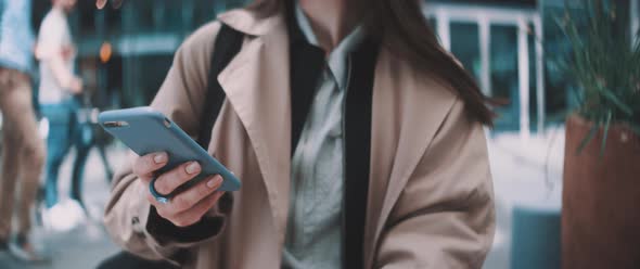 Woman types on sidewalk alt