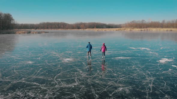 Aerial View Happy Couple Ice Skating Outdoors on a Frozen Lake on a Lovely Sunny Winter Day. Ice alt