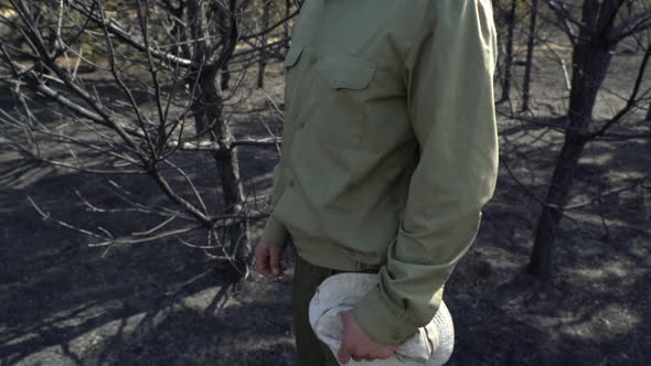 Man in Despair Putting Off His Hat Standing in Burned Forest Af Wildfire Ecological Catastrophe