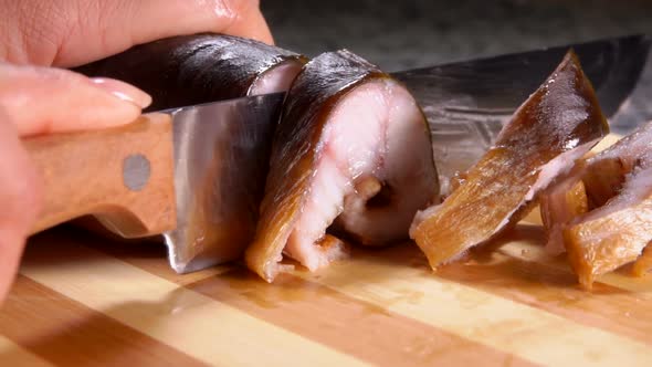 Hostess Cuts Smoked Eel Into Portions alt
