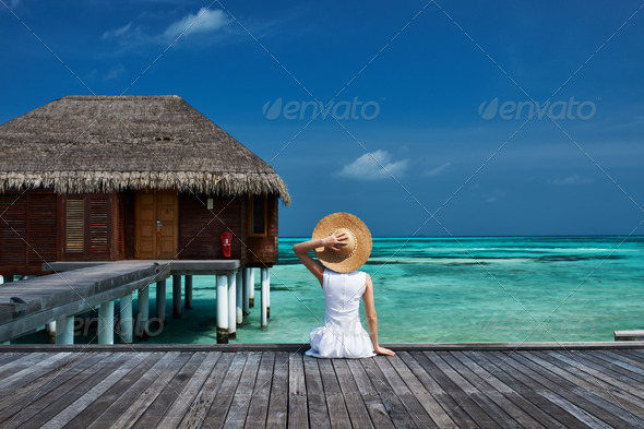 Woman on a beach jetty at Maldives - Stock Photo - Images