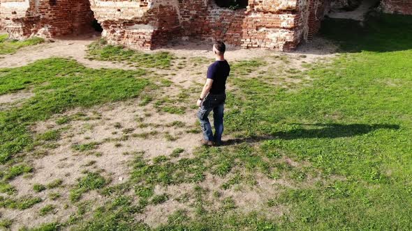 Sightseeing Man Walking By Green Yard Near Old Ancient Building Historical Ruins Discovering World