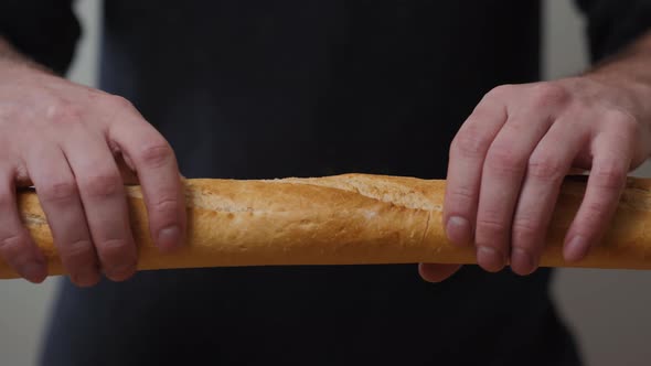 Closeup Organic Delicious Baguette Halves in the Hands of a Man on the Background alt