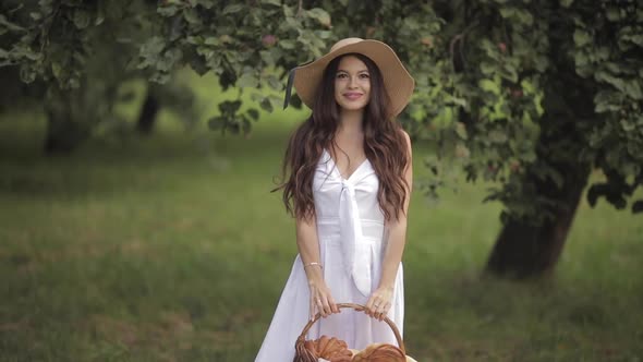 Smiling Lady in a Straw Hat Demonstrating Baked Goods