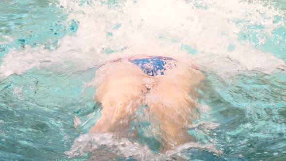 Portrait of Swimmer with Swimming Goggles Diving Into the Clear Blue Water in the Pool