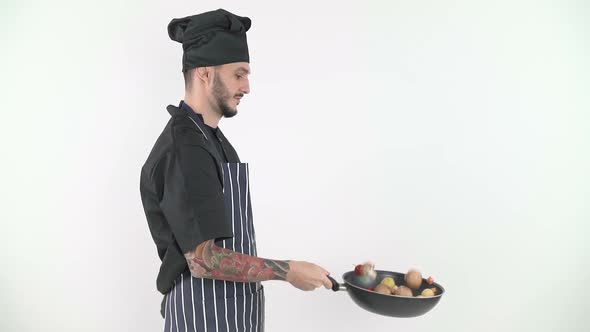 Male Chef Tossing Vegetables From Wok with White Background alt