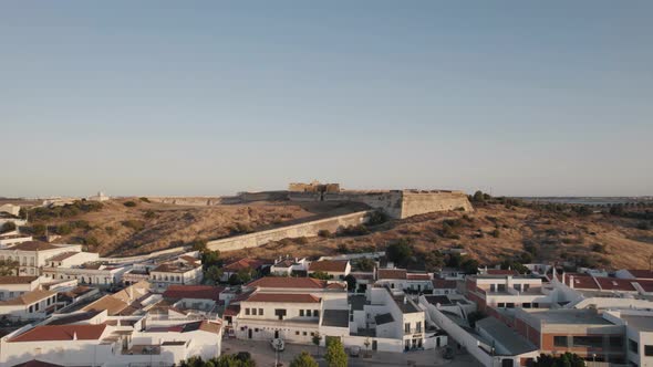 Fly over Castro Marin town towards the medieval Castle on hilltop. Algarve architecture, Portugal alt