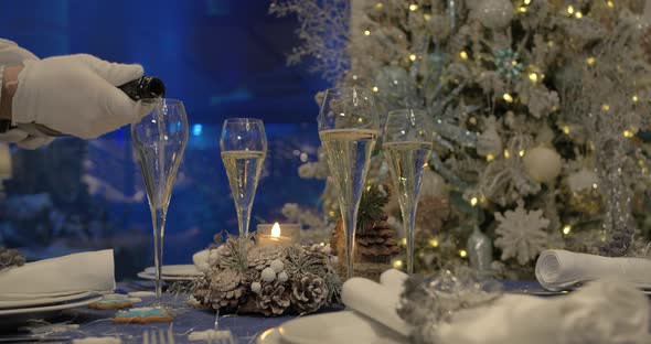 Dining table prepared for Christmas dinner, with a Christmas tree. alt