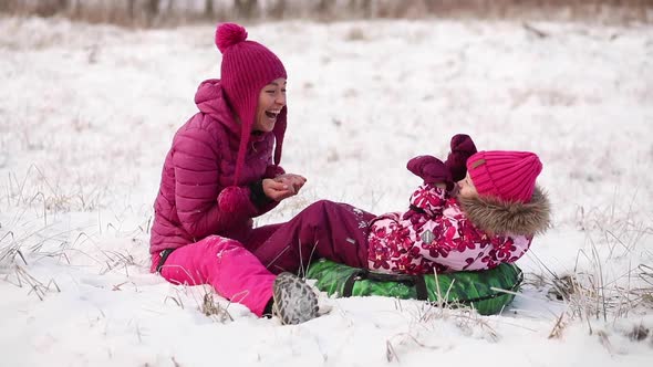 Young Mother and Little Daughter on the Snow