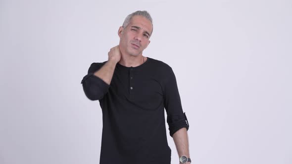 Stressed Persian Man Having Neck Pain Against White Background alt