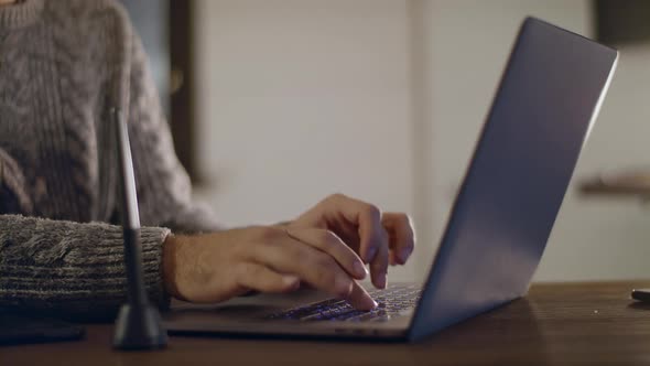 A young, handsome man in glasses works on a laptop.  alt
