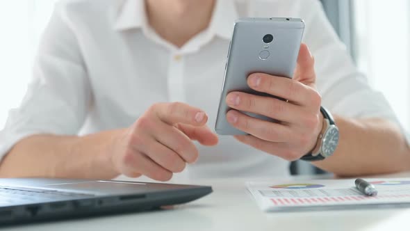 Businessman Checks Business Report On Mobile Phone