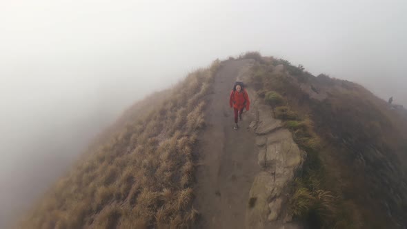 Drone View of Girl Hiker Trekking on Trail in Mountains Covered with Fog alt