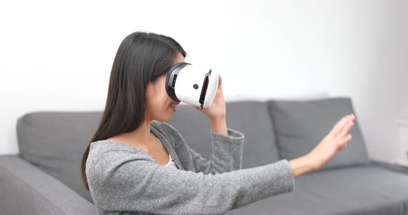 Woman look though virtual reality headset at home  alt