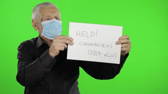 Elderly Grandfather Man in Medical Mask Show Page with Message. Coronavirus alt