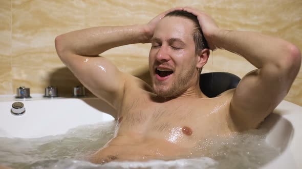 Handsome Man Smiling During Bathing, Satisfied With Pleasure Spa Procedures alt