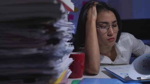 Stressed businesswoman working late at night in the office