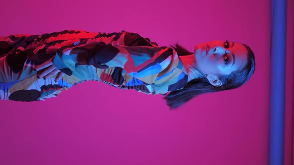 Fashionable Sexy Woman Model of Asian Appearance in a Business Pink Suit