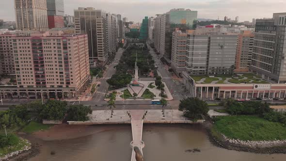 Falling aerial shot behind Kun Iam golden statue in NAPE business area in Macau alt