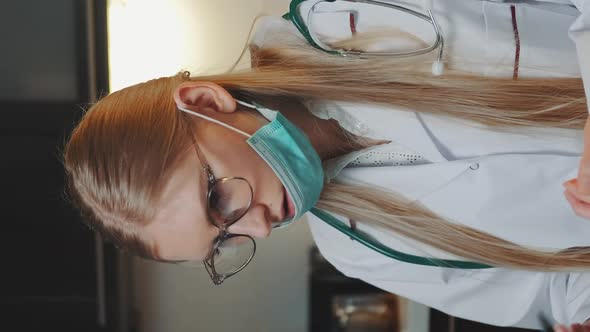 Female Doctor in Medical Gown Making Video Call To Patient From Home alt