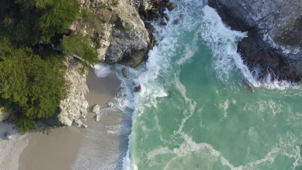 Top Down Forward Pan of McWay Falls and Waves Crashing on the Coast of Big Sur alt