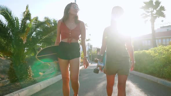 Girlfriend Girls Go To the Park Near Palm Trees Carry Skateboards in Their Hands and Talking and alt