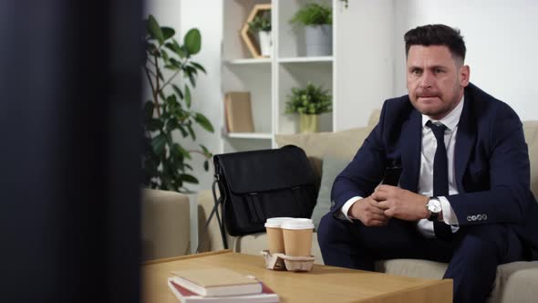 Excited Businessman Watching Sport Competition on TV at Home alt