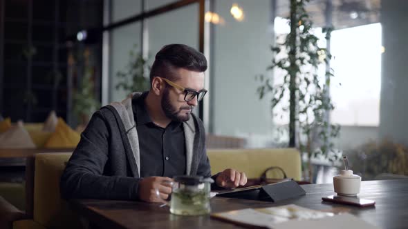 Alone Young Man Is Resting Alone in Cafe in Daytime alt