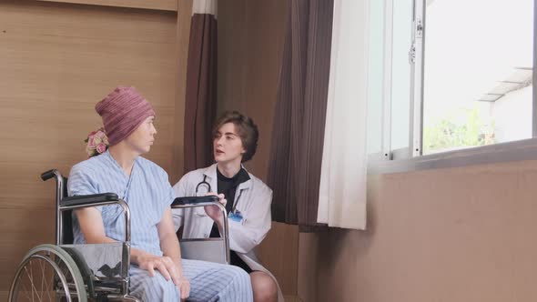 A female doctor pushes wheelchair patient to window to recover from illness. alt