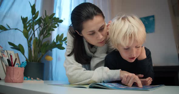 Young Mother with Preschool Child Boy Reading the Book with Labyrinths alt