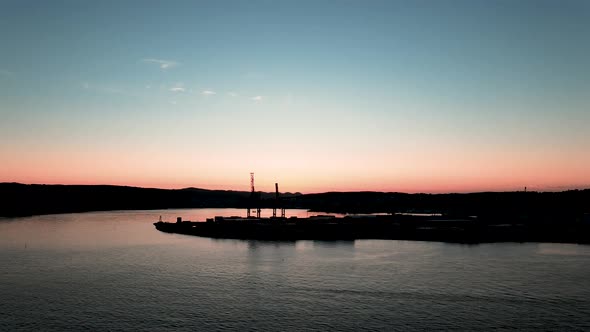 Cranes from Larvik cargo harbor with a beautiful blue and orange sunset in the background alt