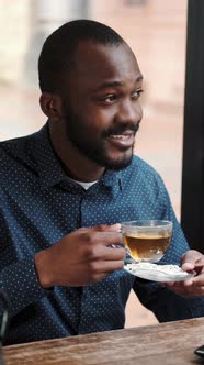 African American Man Drinking Tea in the Restaurant alt