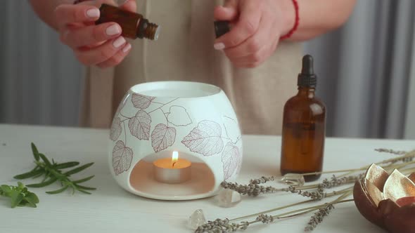 Home SPA concept. Woman preparing an aroma lamp and pouring oil