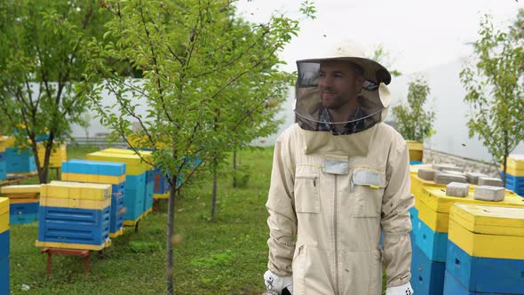 The Beekeeper Walking with Old Bee Smoker on the Apiary alt