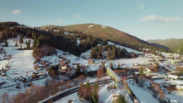 Flight Over a Train That Moves Through a Mountain Valley in Winter