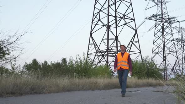 Engineer Inspects a Power Line Using Data From Electric Sensors on a Tablet