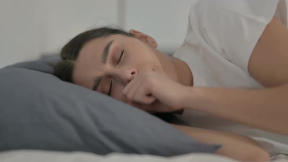 Hispanic Woman having Headache while Sleeping in Bed, Side Pose alt